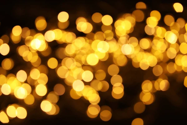 Gouden glitter met bokeh effect op donkere achtergrond — Stockfoto