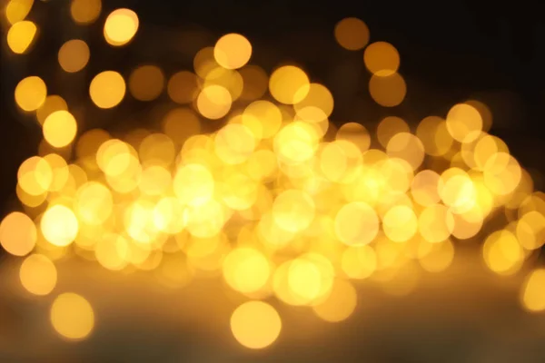 Gouden glitter met bokeh effect op donkere achtergrond — Stockfoto