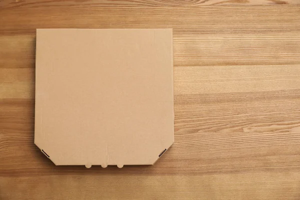 Lepenkové krabici na dřevěné pozadí, pohled shora. Maketa pro design — Stock fotografie