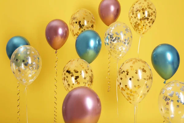 Heldere ballonnen met linten op kleur achtergrond — Stockfoto