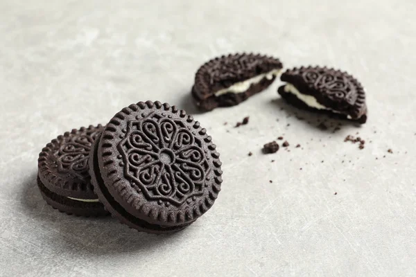 Biscoitos de chocolate saborosos com creme no fundo cinza. Espaço para texto — Fotografia de Stock