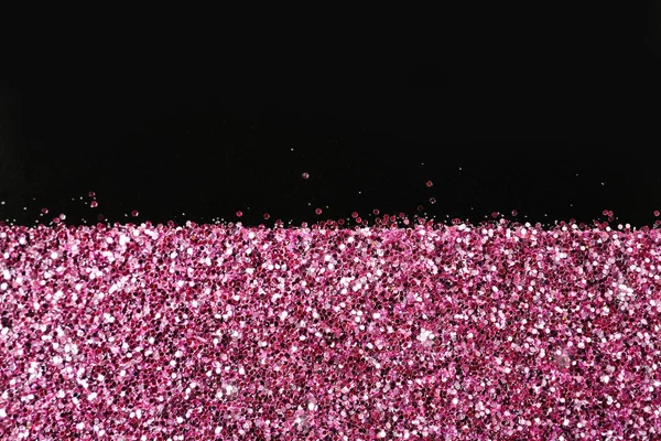 Rose gold glitter on black background, top view with space for text