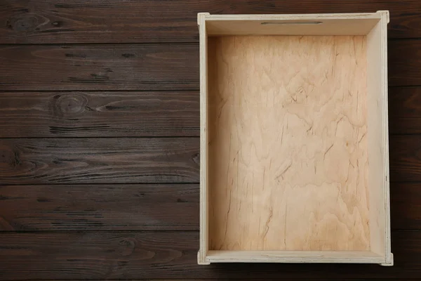 Lege kist op houten achtergrond, bovenaanzicht met ruimte voor tekst — Stockfoto
