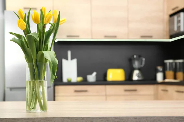 Glasvase mit Tulpen auf dem Tisch in der Küche — Stockfoto