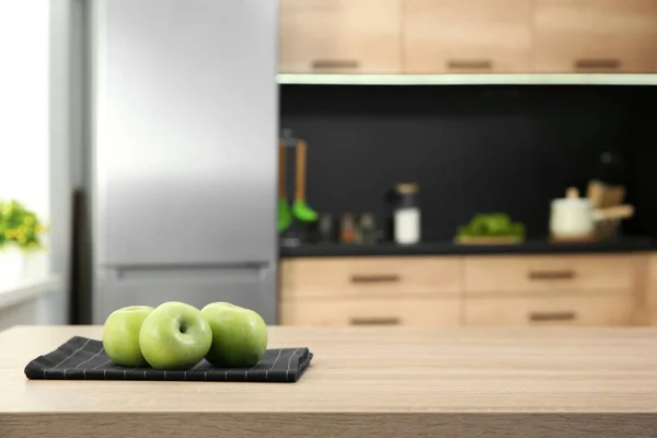 Maçãs frescas na mesa na cozinha, foco seletivo — Fotografia de Stock