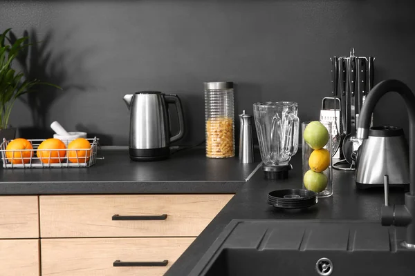 Eleganta köksbänken med husgeråd, vitvaror och produkter — Stockfoto