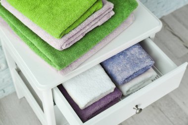 Çekmece ve temiz yumuşak havlu banyoda içeren tablo