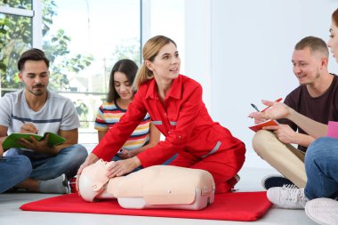 CPR manken ilkyardım sınıfı kapalı gösteren eğitmen