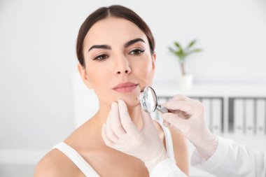 Dermatolog genç hastanın Doğum lekesi Büyüteç kliniği ile incelenmesi