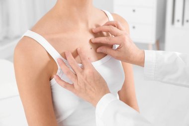 Dermatolog klinikte hastanın doğum lekesini inceliyor.