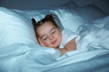 Güzel küçük kız yatakta gece uyku. Yatmadan zamanlama