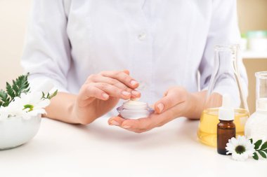 Kadın dermatolog cilt bakım ürünü masada, closeup test