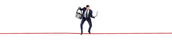 Businessman with briefcase and laptop balancing on rope against white background — Stock Photo, Image