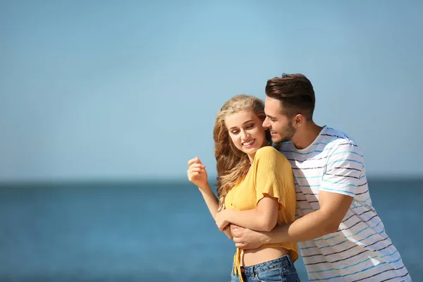Glückliches junges Paar am Strand an sonnigem Tag — Stockfoto