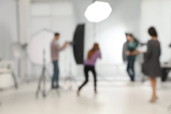 Estudio fotográfico borroso con equipo profesional y equipo de trabajadores — Foto de Stock