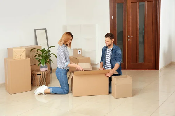 Felice coppia disimballaggio scatola in movimento nella loro nuova casa — Foto Stock