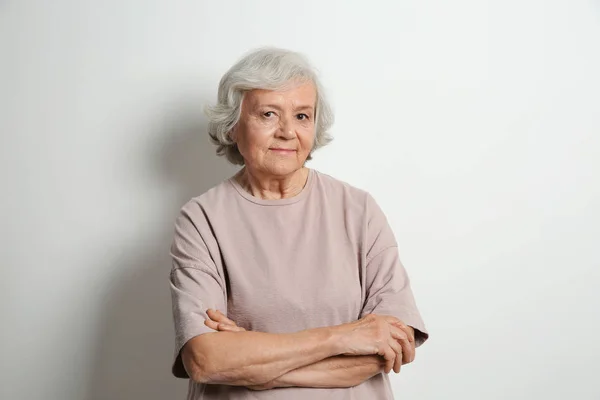 Portret van de bejaarde vrouw op lichte achtergrond — Stockfoto