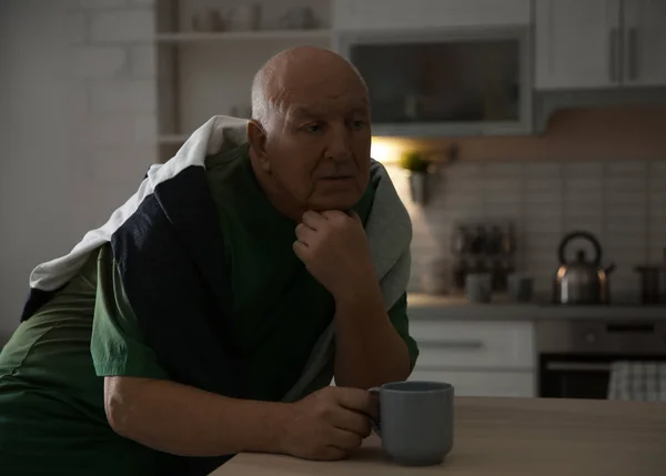 Homem idoso com xícara de chá à mesa na cozinha — Fotografia de Stock