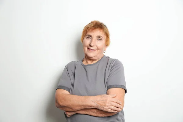 Retrato de mulher idosa em fundo claro — Fotografia de Stock