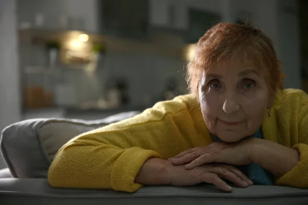Portret starszą kobietę na kanapie w domu — Zdjęcie stockowe