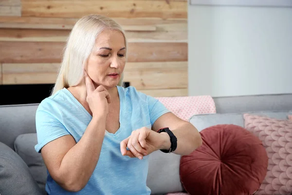 Mujer madura revisando el pulso con los dedos en casa. Espacio para texto —  Fotos de Stock