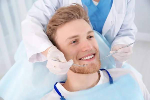 Стоматолог, осматривающий зубы пациента в современной клинике — стоковое фото