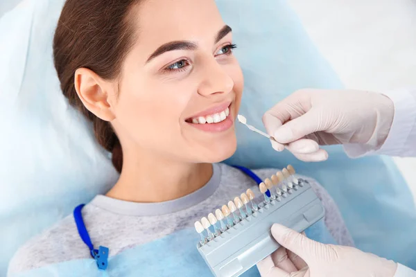 Zahnarzt wählt Zahnfarbe des Patienten mit Palette in Klinik aus — Stockfoto