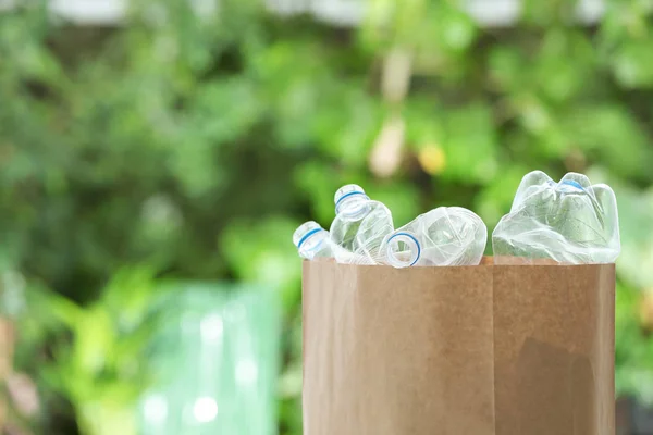 Gebrauchte Plastikflaschen in Papiertüten auf verschwommenem Hintergrund, Platz für Text. Recycling-Problem — Stockfoto