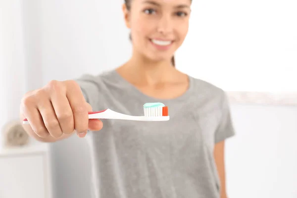 Young woman with toothbrush and paste in bathroom. Teeth care — Stock Photo, Image