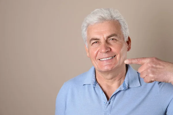 Mature man with healthy teeth on color background. Space for text — Stock Photo, Image