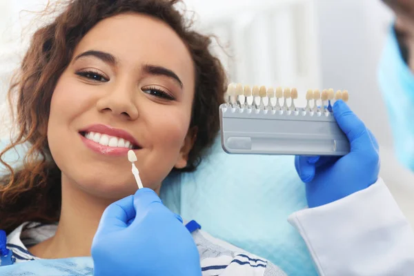 Zahnarzt passend zur Zahnfarbe des Patienten mit Palette im Büro — Stockfoto