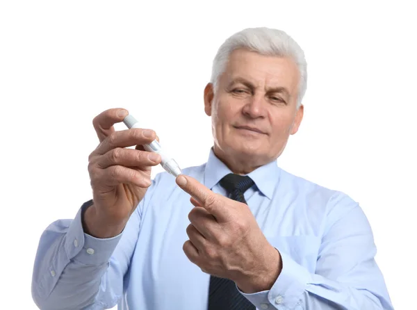 Za pomocą pióra lancet na białym tle starszy mężczyzna. Kontroli cukrzycy — Zdjęcie stockowe