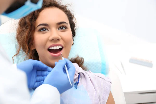 Zahnarzt, der die Zähne der afrikanisch-amerikanischen Frau mit Sonde im Krankenhaus untersucht. Raum für Text — Stockfoto