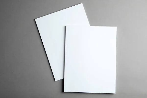 Folletos con cubiertas en blanco sobre fondo gris, vista superior. Prepárate para el diseño —  Fotos de Stock