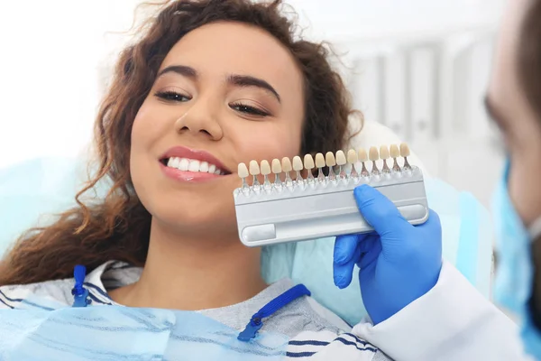 Zahnarzt passend zur Zahnfarbe des Patienten mit Palette im Büro — Stockfoto