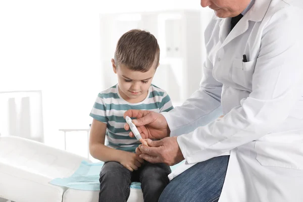 Kleine patiënt en arts met een lancet pennen in het ziekenhuis. Diabetes control — Stockfoto