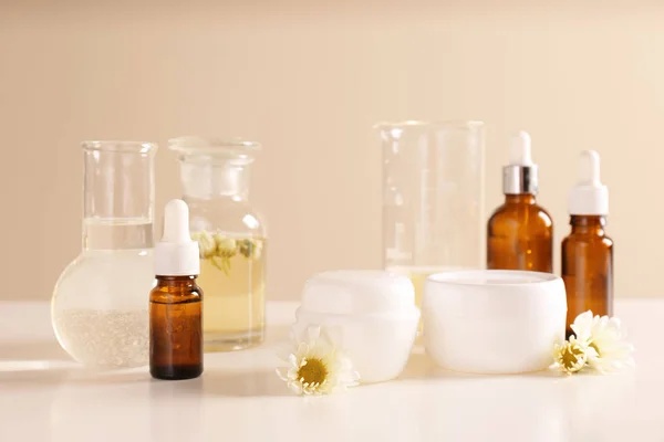 Productos para el cuidado de la piel, ingredientes y cristalería de laboratorio en la mesa. Investigación dermatológica — Foto de Stock