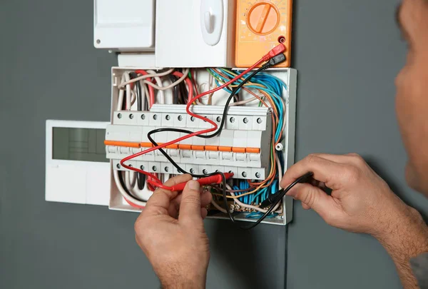 Electricista con voltaje de comprobación del probador en interiores, primer plano — Foto de Stock