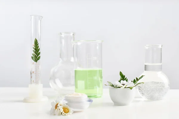 Produto de cuidados com a pele, ingredientes e artigos de vidro de laboratório na mesa. Investigação Dermatológica — Fotografia de Stock