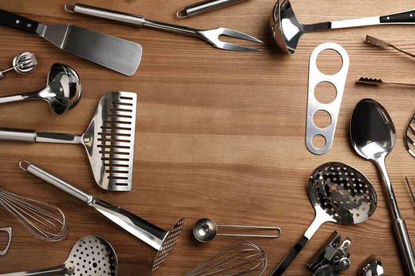 Composición plana con diferentes utensilios de cocina sobre fondo de madera, espacio para texto —  Fotos de Stock