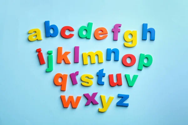 Magnetbuchstaben aus Kunststoff auf farbigem Hintergrund, Draufsicht. alphabetische Reihenfolge — Stockfoto