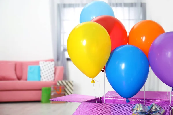 Подарочная коробка с яркими воздушными шарами в гостиной. Пространство для текста — стоковое фото