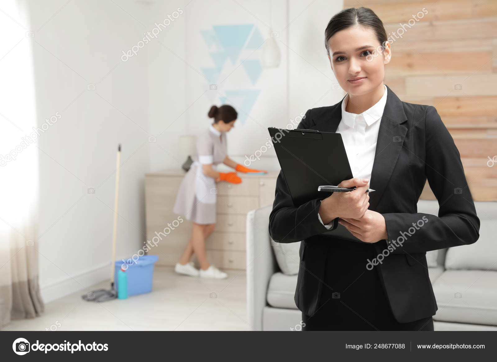 Housekeeping manager checking maid work in hotel room Stock Photo by