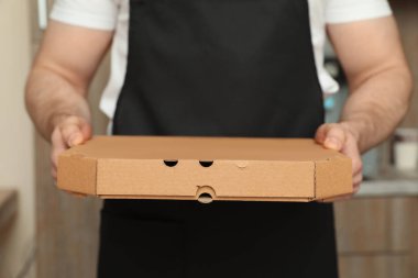Garson önlük pizza kutusu kapalı, closeup ile. Gıda dağıtım hizmeti