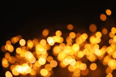 Koyu arka plan üzerinde bokeh etkisi ile altın glitter