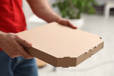 Kurye ile pizza kutusu arka plan bulanık, closeup üzerinde. Metin için yer
