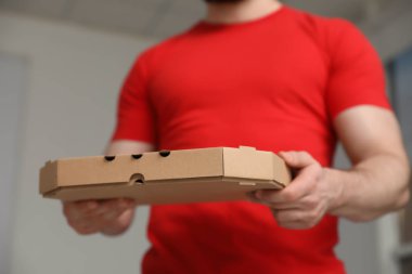 Kurye ile pizza kutusu arka plan bulanık, closeup üzerinde