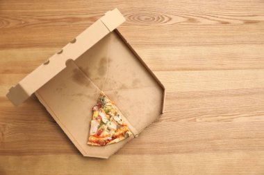 Pizza parça ahşap arka plan, metin için yer ile üstten görünüm ile karton kutu