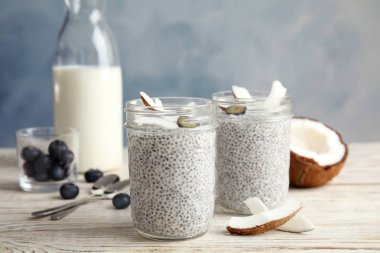 Lezzetli chia tohum puding kavanoz ve malzemelerin tablo üzerine Hindistan cevizi ile