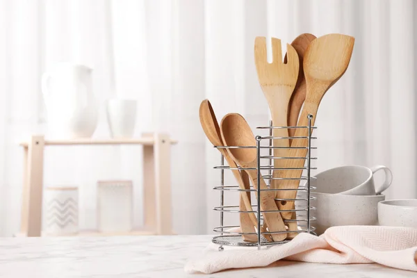 Wooden utensils and dishware on table in kitchen. Space for text — Stock Photo, Image